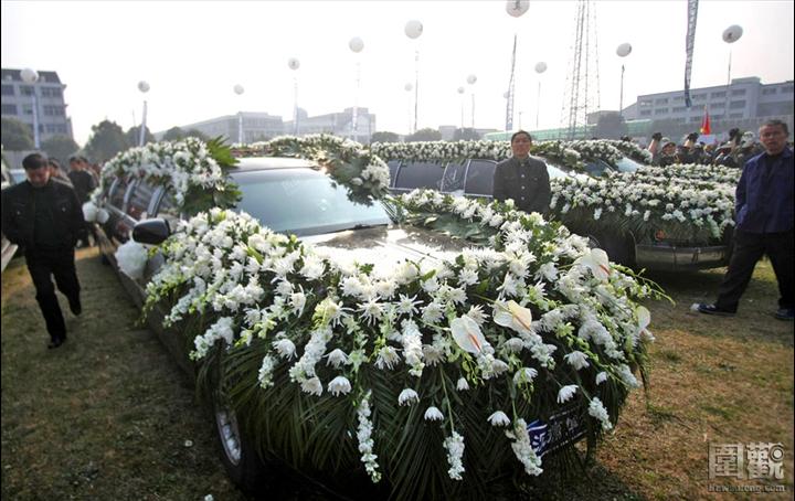 葬礼现场,作为送葬车队的9辆加长林肯轿车在租用的体育场上一字排开