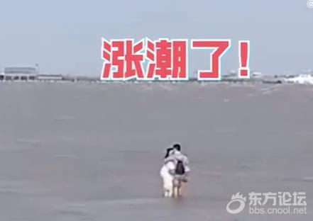 情侣游玩遇涨潮站水中亲热 ,岸边人员大喊“别亲了”